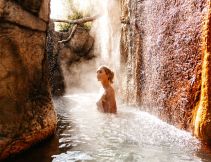 a woman soaking in an outdoor hot spring at Deep Blue Hotel